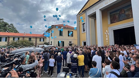 Palloncini azzurri all'uscita di chiesa dopo i funerali della famiglia uccisa a Paderno Dugnano